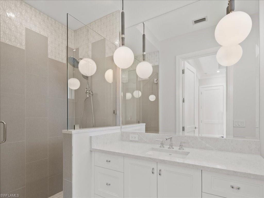 292 Bahia Point Naples, FL 34103 - Photo 38 of 50 a bathroom with a sink vanity and a mirror