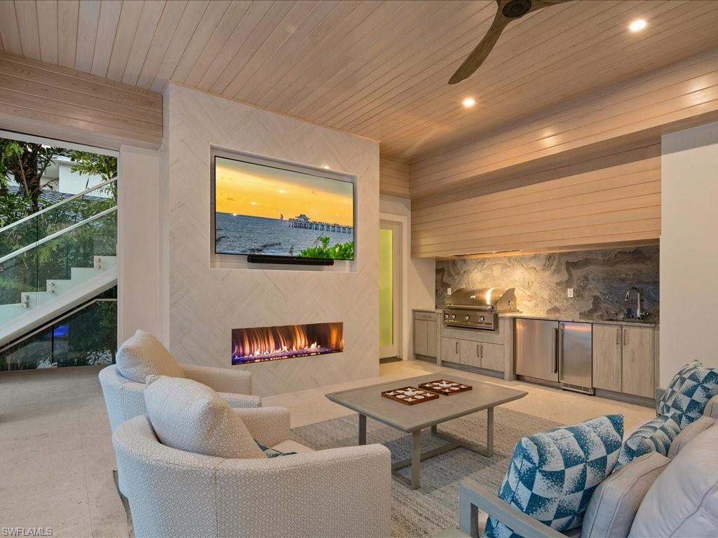 292 Bahia Point Naples, FL 34103 - Photo 44 of 50 a living room with furniture and a flat screen tv