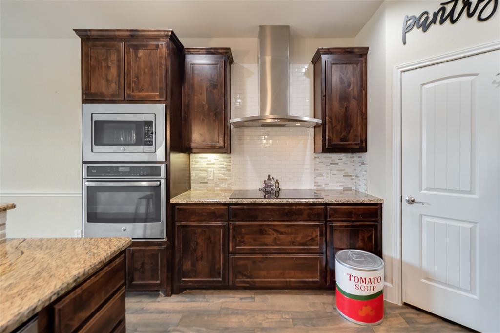 1663 Fraser Drive Burleson, TX 76028 - Photo 14 of 22 Kitchen with tasteful backsplash, appliances with stainless steel finishes, wall chimney range hood, and light wood-style floors