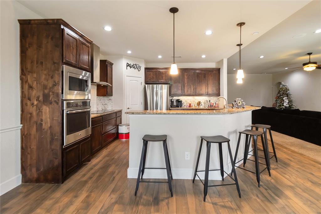 1663 Fraser Drive Burleson, TX 76028 - Photo 16 of 22 Kitchen with hanging light fixtures, backsplash, dark wood-type flooring, recessed lighting, and stainless steel appliances