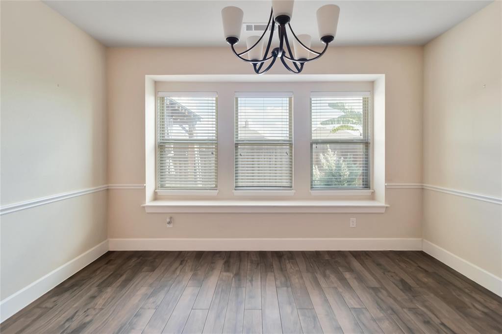 1663 Fraser Drive Burleson, TX 76028 - Photo 17 of 22 Unfurnished dining area with plenty of natural light, dark wood-style floors, and a chandelier