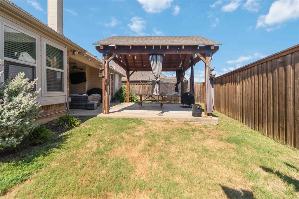 1663 Fraser Drive Burleson, TX 76028 - Photo 20 of 22 Fenced backyard with a patio and a ceiling fan