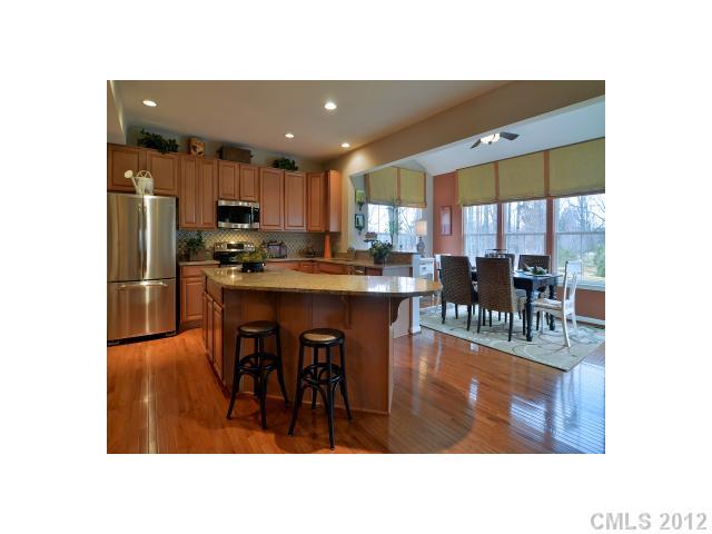 1617 Ridgehaven Road, Unit MB241 Waxhaw, NC 28173 - Photo 1 of 4 a kitchen with stainless steel appliances kitchen island granite countertop a refrigerator a stove a kitchen island a dining table and chairs with wooden floor
