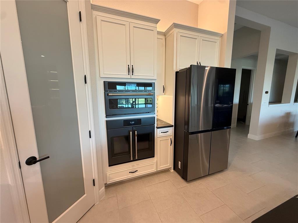 10958 Rustic Timber Loop San Antonio, FL 33576 - Photo 11 of 48 a kitchen with stainless steel appliances a refrigerator and cabinets