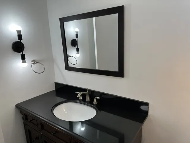 a bathroom with a sink vanity and a mirror