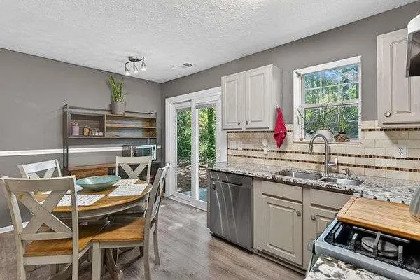 a kitchen with stainless steel appliances granite countertop a stove a sink and a refrigerator