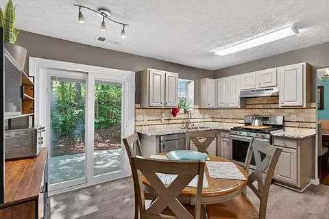 a kitchen with kitchen island granite countertop wooden cabinets and a refrigerator