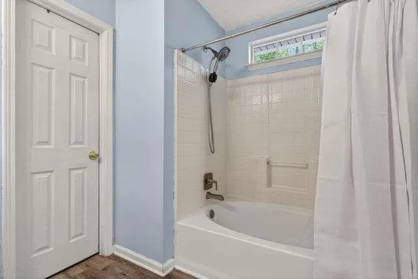 a bathroom with a tub shower and a sink