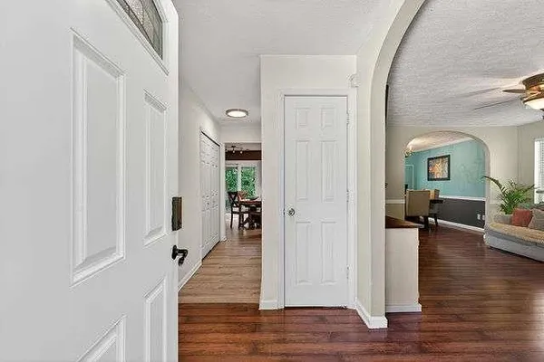 a view of a hallway with wooden floor windows and livingroom