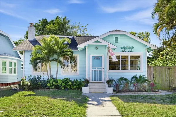 a front view of a house with a yard and potted plants