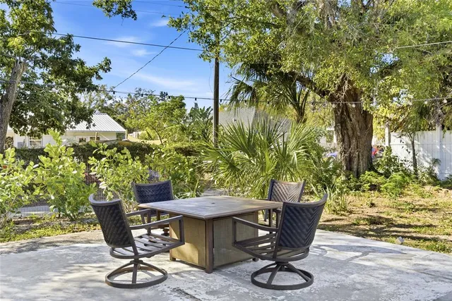 a view of a table and chairs in back yard of the house