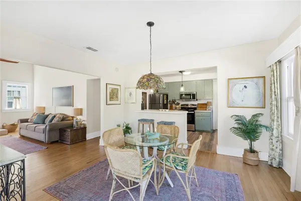 a dining room with furniture a chandelier and wooden floor