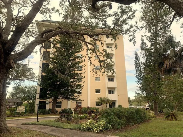 a view of a tall white building among the trees