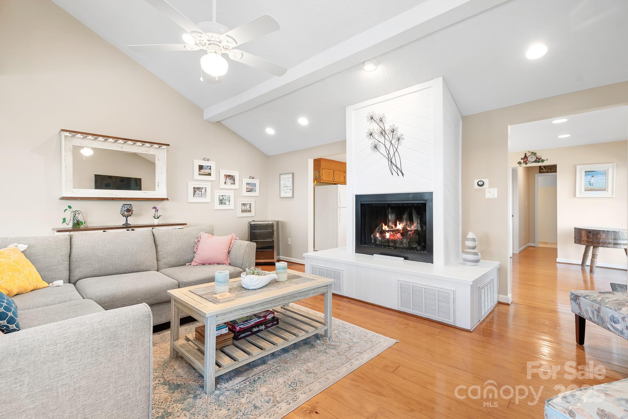 8293 Luckey Point Road Denver, NC 28037 - Photo 28 of 33 a living room with furniture a fireplace and a flat screen tv