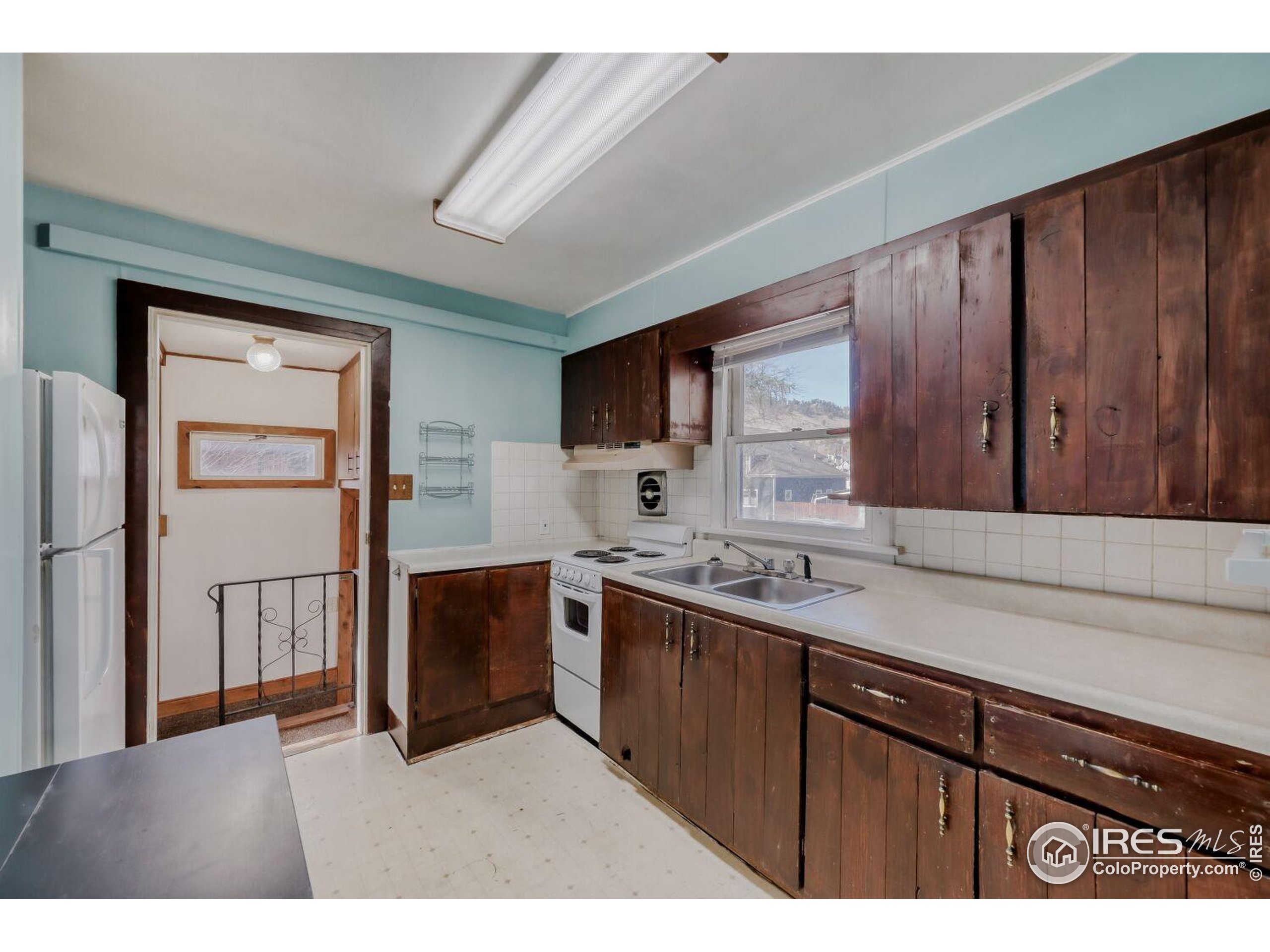 534 Dewey Avenue Boulder, CO 80304 - Photo 7 of 17 a kitchen with stainless steel appliances granite countertop a refrigerator a sink dishwasher and wooden cabinets with wooden floor