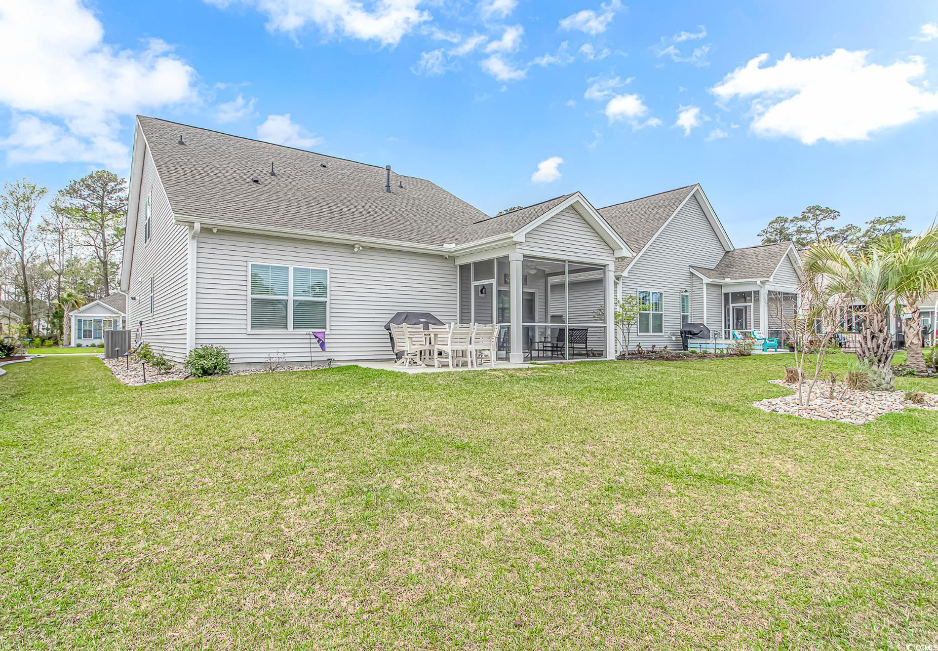 222 Sundew Loop Little River, SC 29566 - Photo 34 of 40 Back of house featuring a lawn, a sunroom, a shing