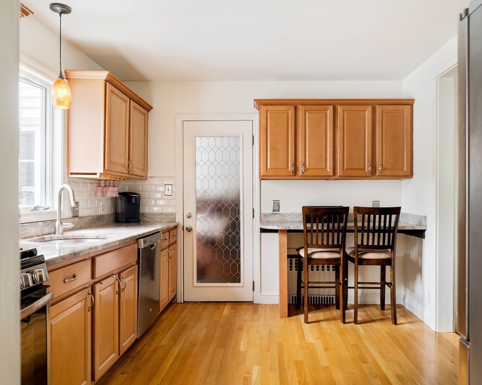 7 St Marys Road Milton, MA 02186 - Photo 9 of 31 a kitchen with stainless steel appliances granite countertop a stove top oven a sink dishwasher and a refrigerator with wooden floor