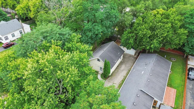 an aerial view of a house with a yard and large trees