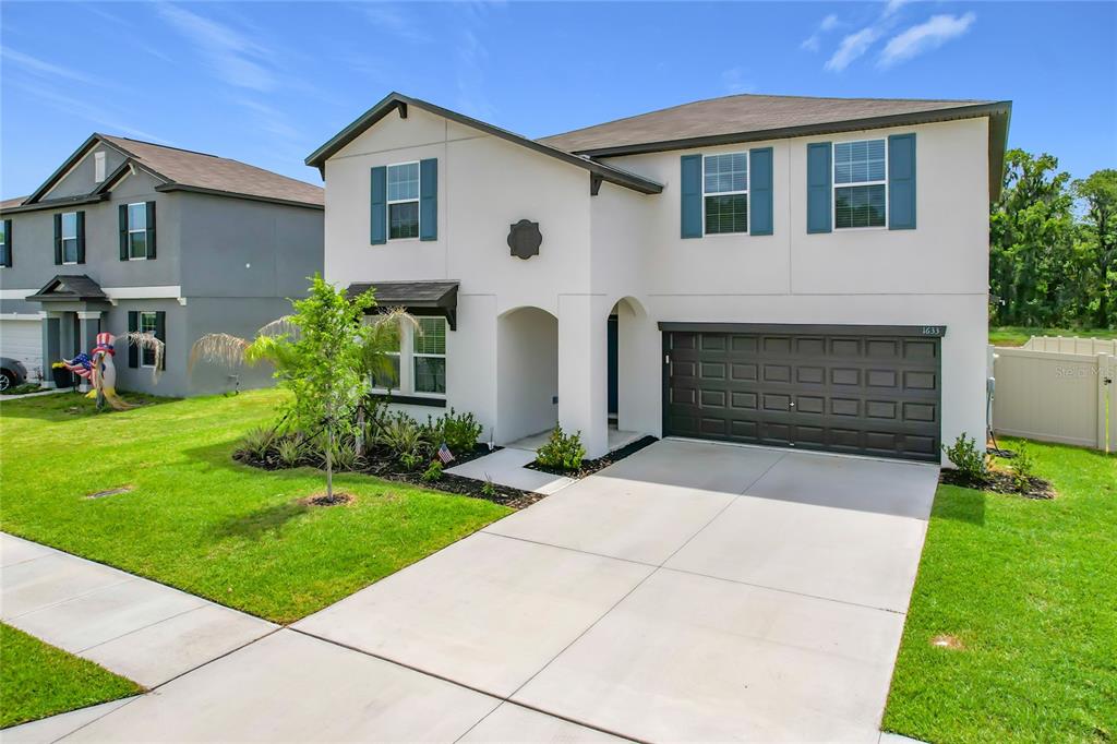 1633 Red Loop Lakeland, FL 33801 - Photo 2 of 60 a front view of a house with a yard and garage