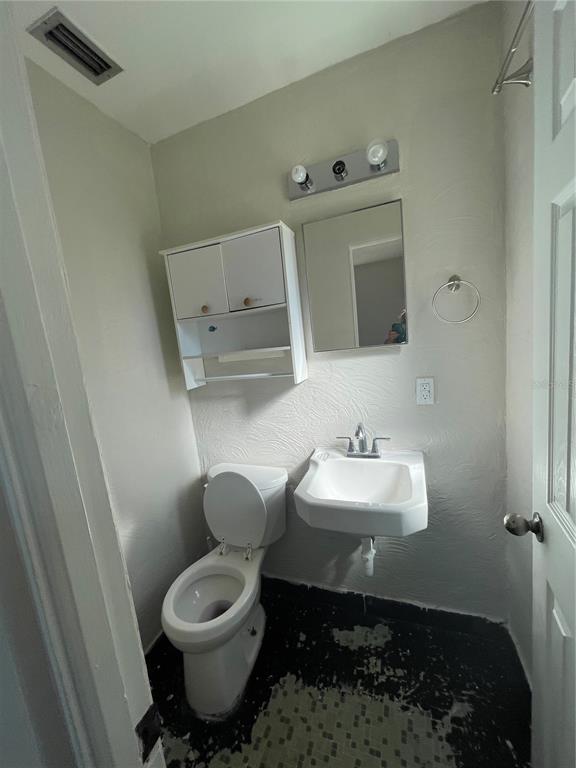 632 Cardinal Street Ocoee, FL 34761 - Photo 6 of 29 a bathroom with a toilet sink and mirror