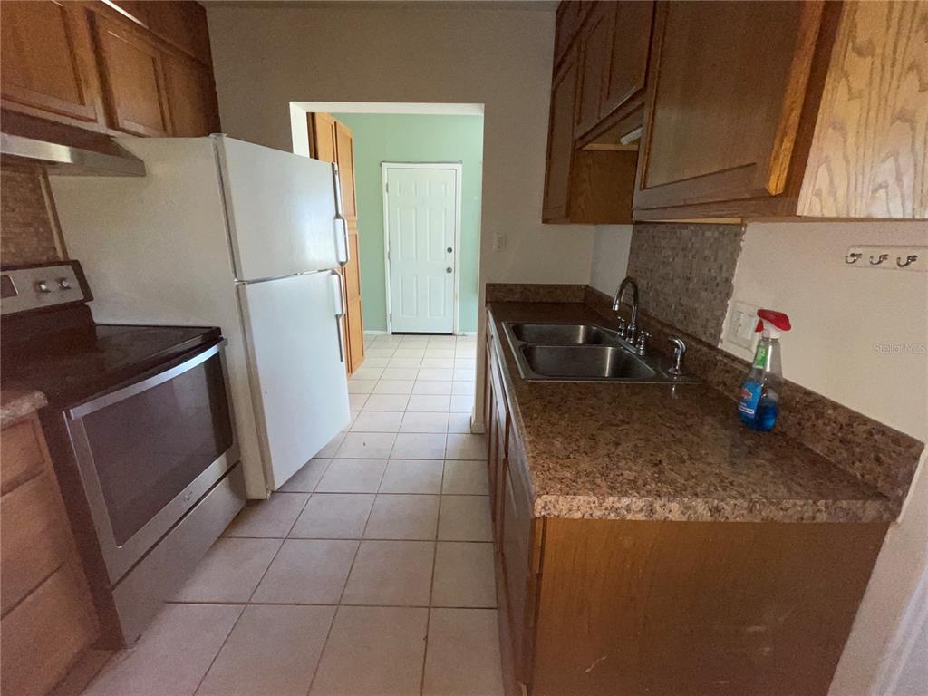 632 Cardinal Street Ocoee, FL 34761 - Photo 7 of 29 a kitchen with granite countertop a refrigerator and a sink