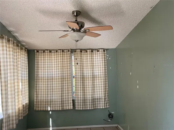 a view of a livingroom with a ceiling fan and window