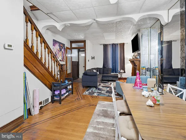 a living room with furniture hard wood floor and a chandelier