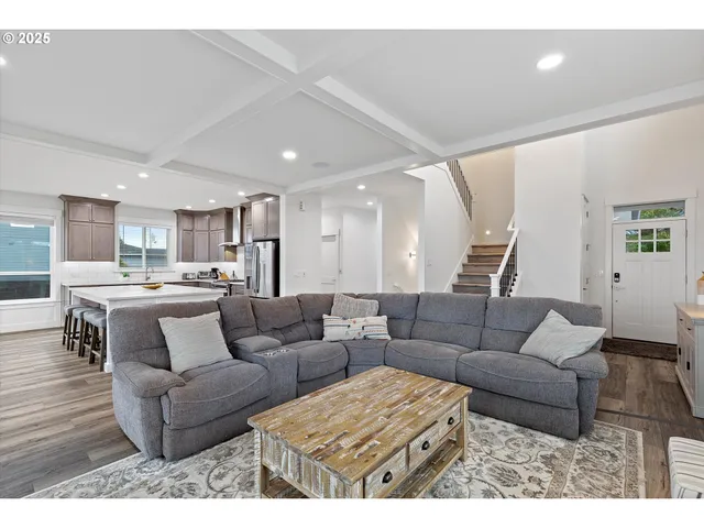 a living room with furniture and a view of kitchen