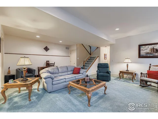 a living room with furniture a flat screen tv and a window