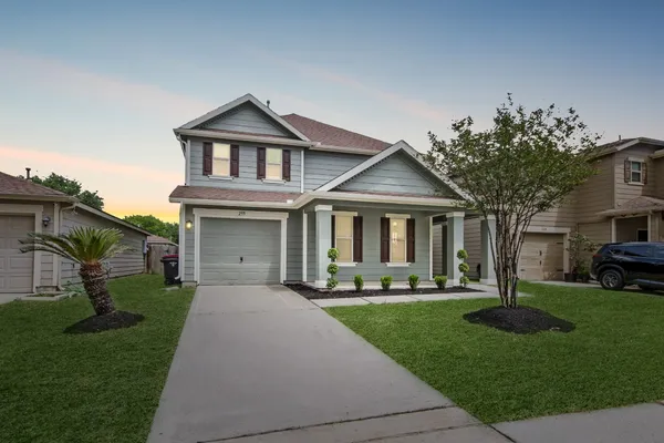 a front view of a house with a yard and potted plants