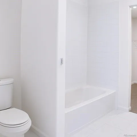 a white bath tub sitting next to a toilet