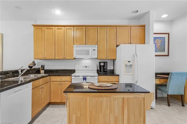 a kitchen with stainless steel appliances granite countertop a refrigerator a sink a stove and white cabinets