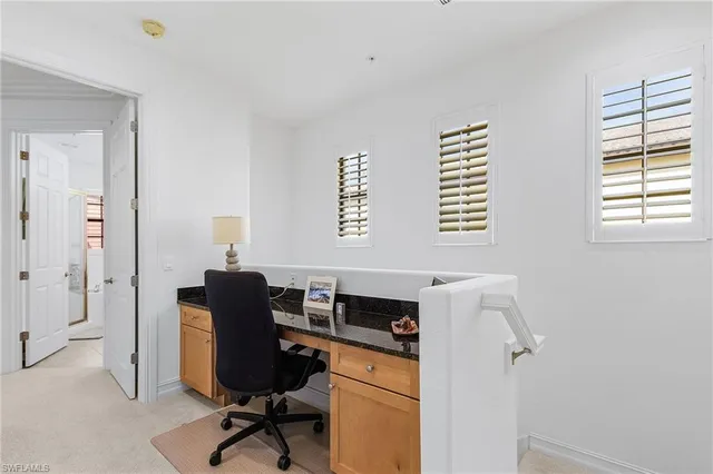 a view of a workspace with furniture and a window