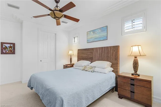 a bedroom with a bed and a lamp on the dresser