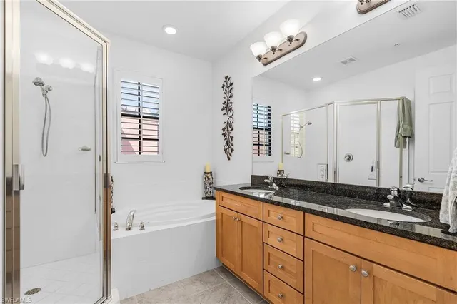 a spacious bathroom with a granite countertop sink mirror and a bathtub