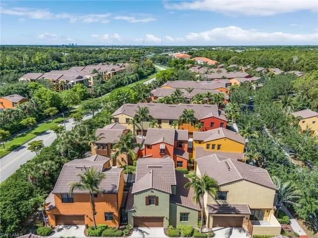 an aerial view of residential houses with outdoor space and trees