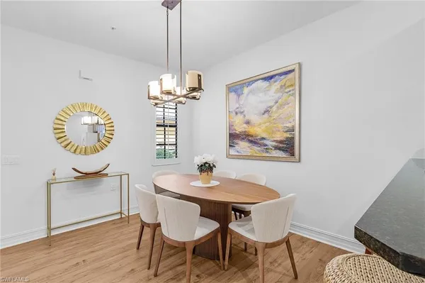 a dining room with chandelier and wooden floor