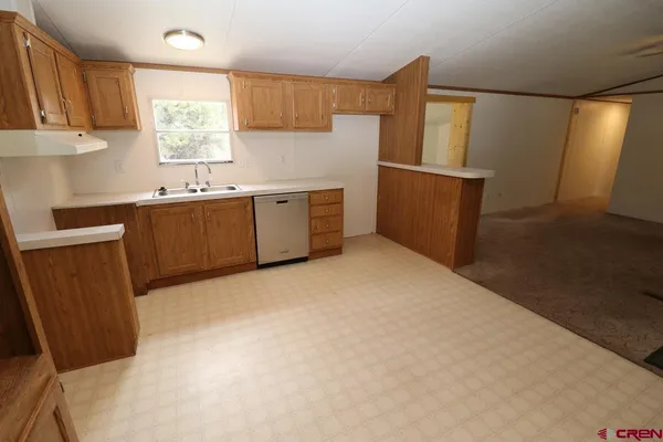 a view of a kitchen with a sink and a refrigerator