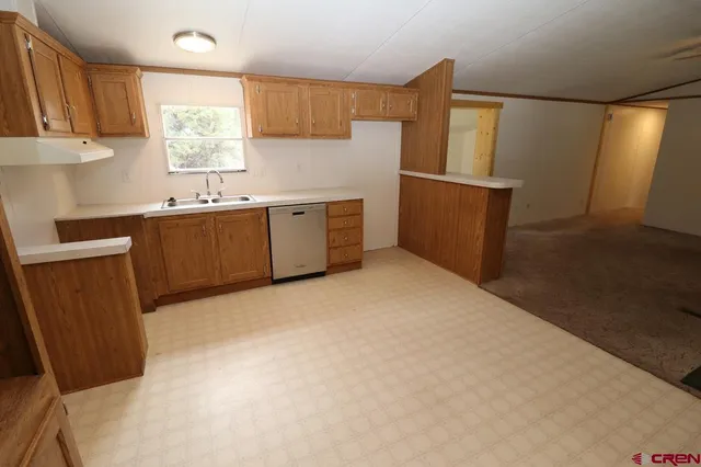 a view of a kitchen with a sink and a refrigerator