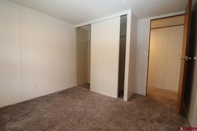 a view of a hallway with a livingroom and a bathroom