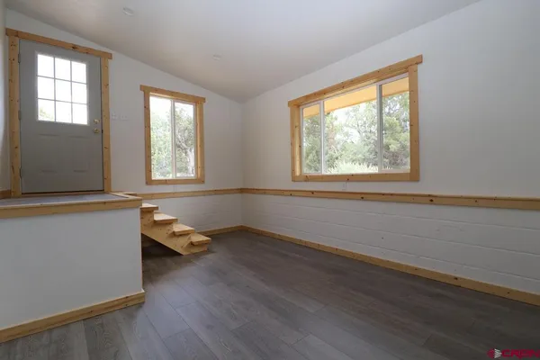 a backyard of a house with plants and large trees