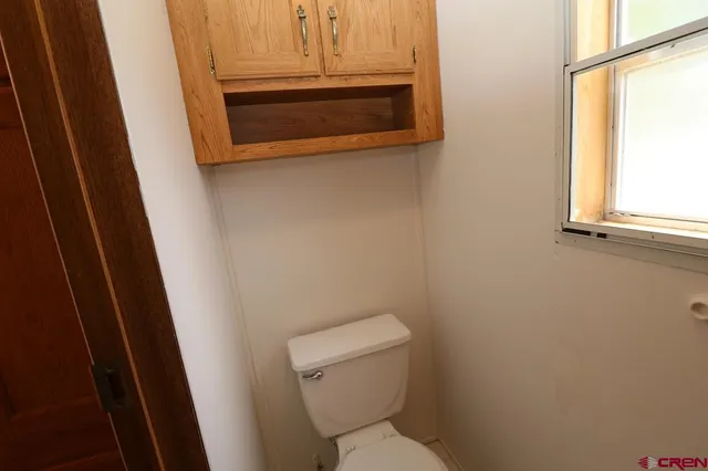 a bathroom with a toilet and a window