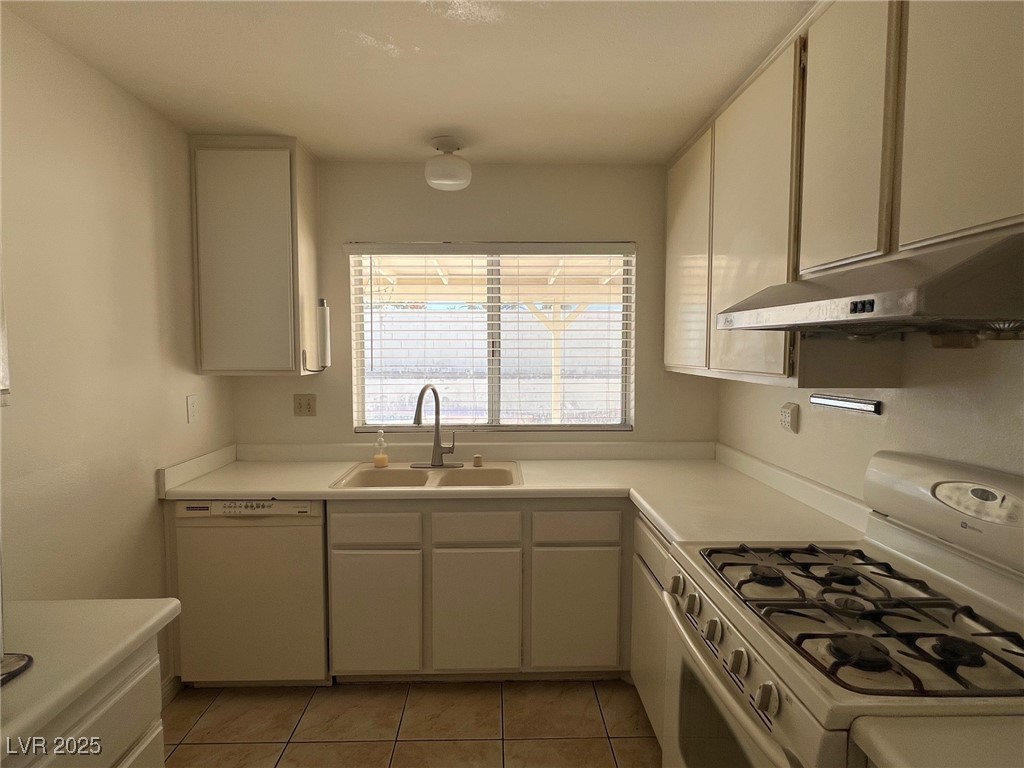 3737 Prosperity Lane Las Vegas, NV 89147 - Photo 14 of 36 Kitchen with white appliances, light countertops, light tile patterned floors, and under cabinet range hood