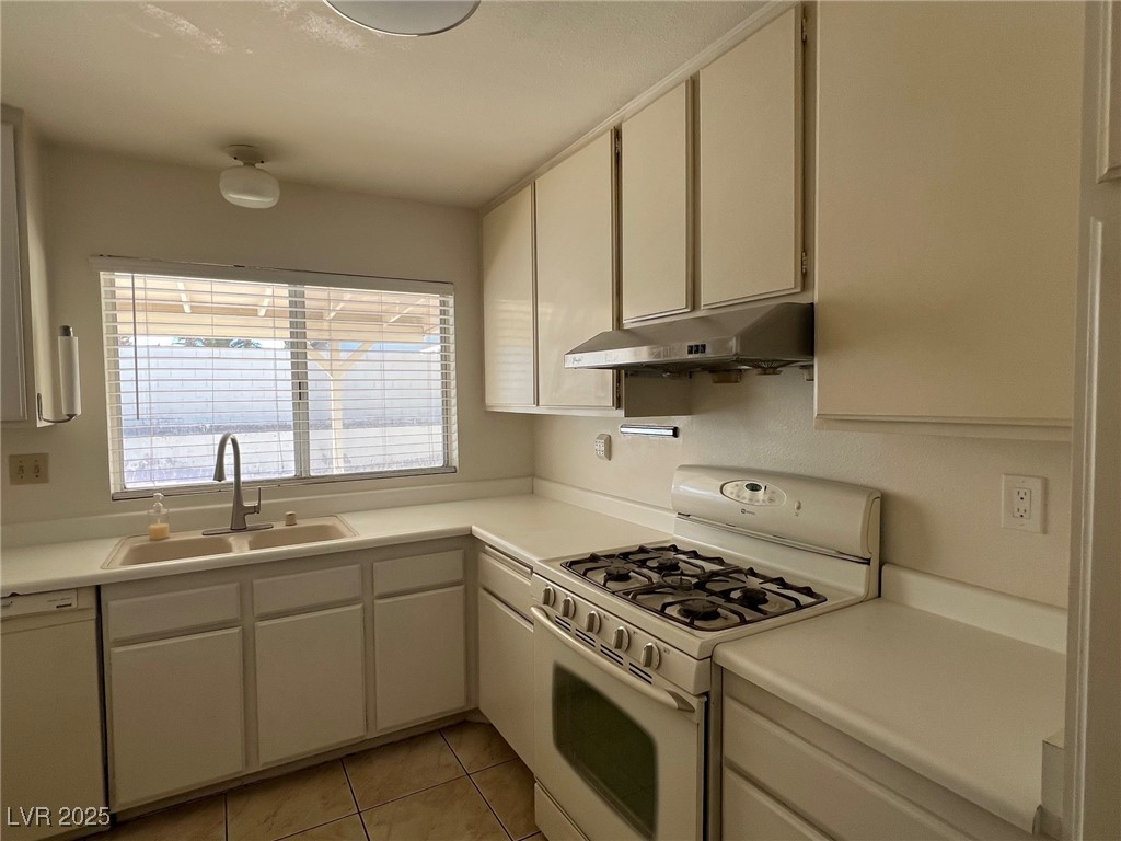 3737 Prosperity Lane Las Vegas, NV 89147 - Photo 15 of 36 Kitchen with white appliances, light countertops, light tile patterned floors, and under cabinet range hood