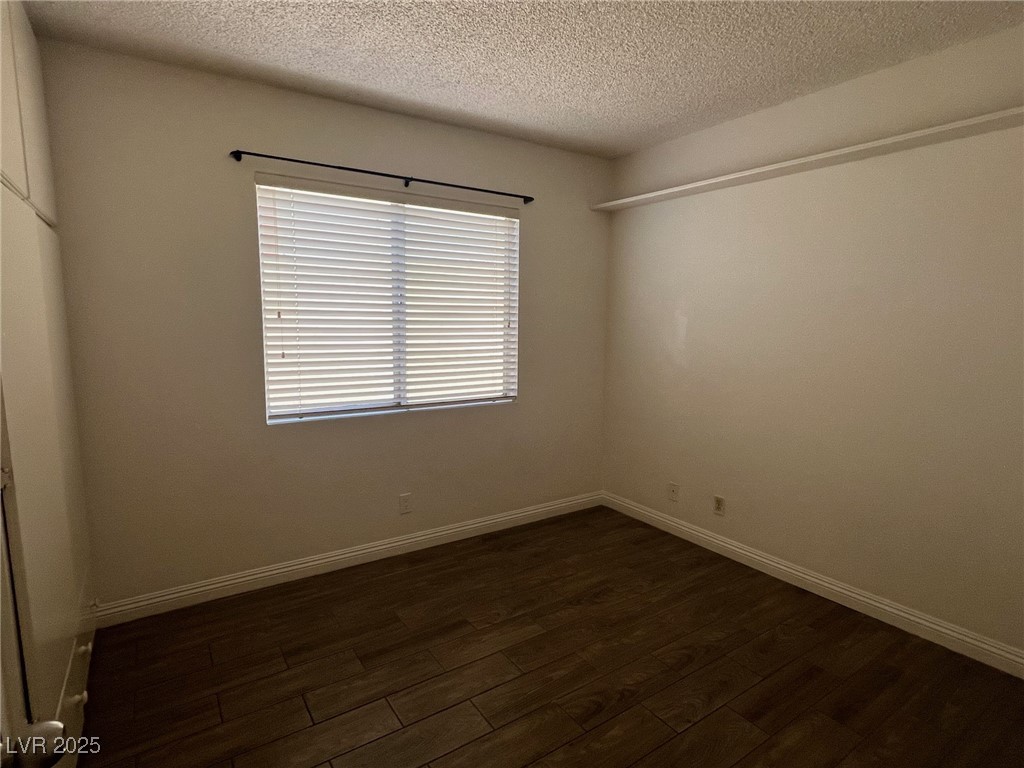 3737 Prosperity Lane Las Vegas, NV 89147 - Photo 16 of 36 Unfurnished room with a textured ceiling and dark wood-type flooring