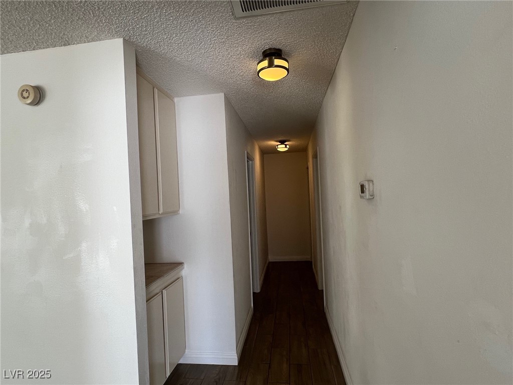 3737 Prosperity Lane Las Vegas, NV 89147 - Photo 17 of 36 Hall with a textured ceiling and dark wood-style floors