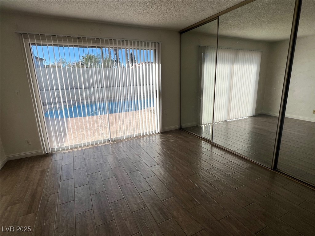 3737 Prosperity Lane Las Vegas, NV 89147 - Photo 21 of 36 Unfurnished bedroom featuring dark wood-type flooring, a closet, and a textured ceiling