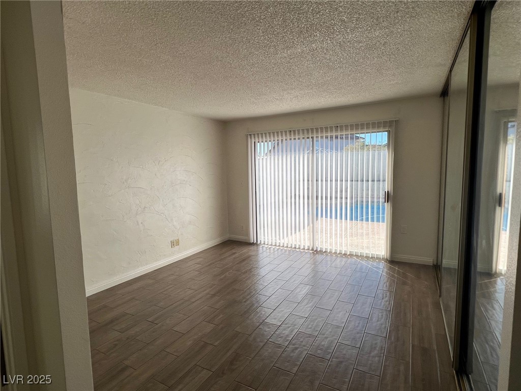 3737 Prosperity Lane Las Vegas, NV 89147 - Photo 22 of 36 Unfurnished room with a textured wall, dark wood finished floors, and a textured ceiling