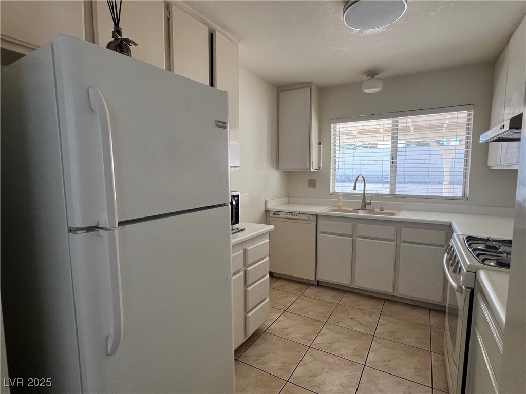 3737 Prosperity Lane Las Vegas, NV 89147 - Photo 23 of 36 Kitchen with white appliances, light countertops, light tile patterned flooring, and under cabinet range hood