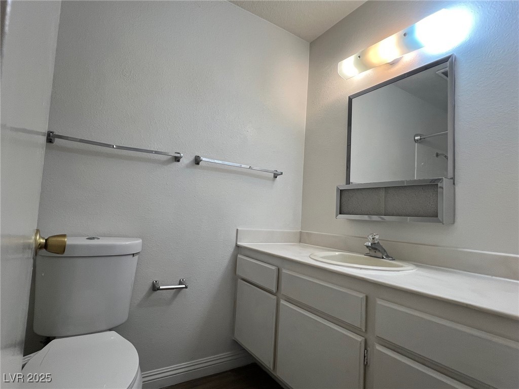 3737 Prosperity Lane Las Vegas, NV 89147 - Photo 25 of 36 Bathroom with vanity, a textured wall, and dark wood-type flooring
